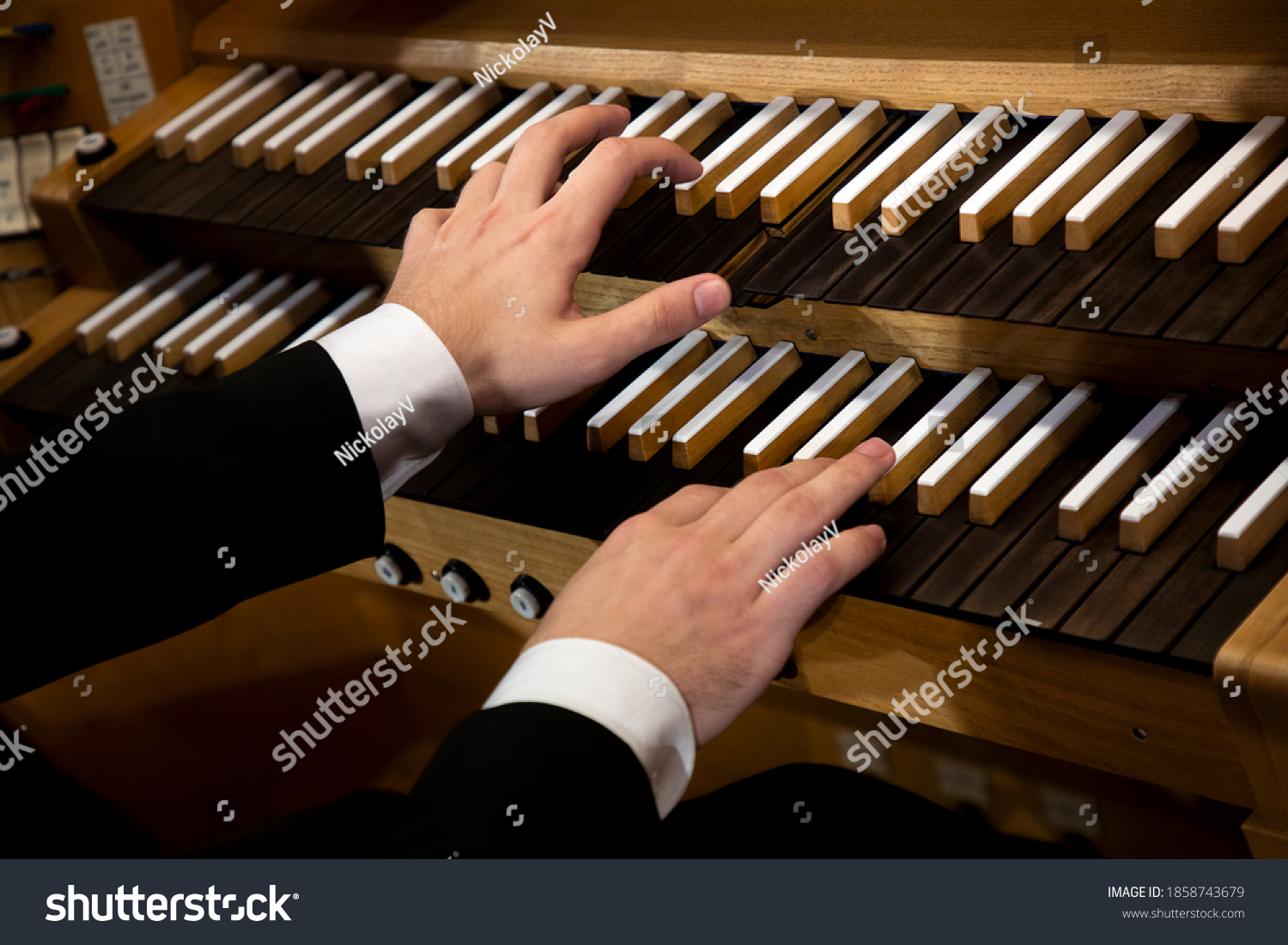 Close up view of a organist hands playing a pipe organ #1858743679
