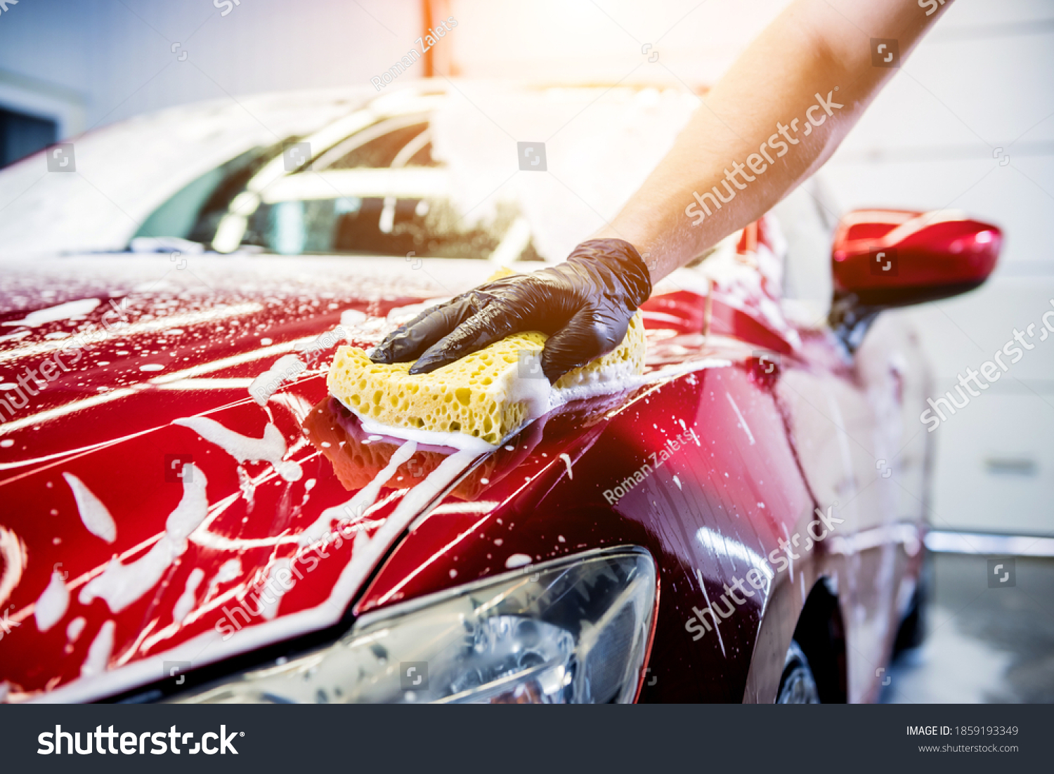 Worker washing red car with sponge on a car wash #1859193349