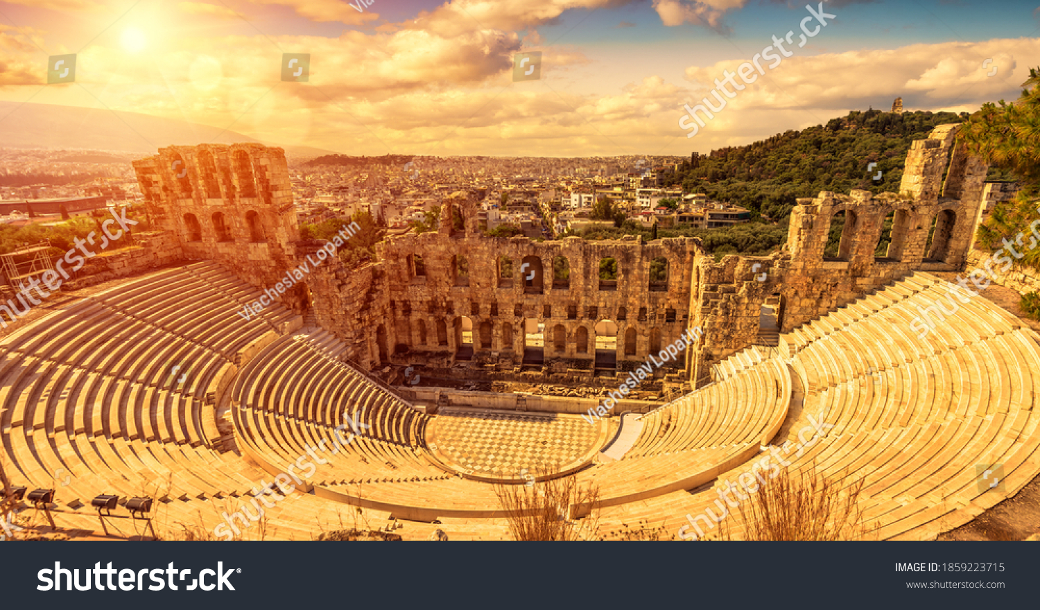Odeon of Herodes Atticus at sunset, Athens, Greece. It is old famous landmark of Athens. Scenic panorama of ancient Greek monument overlooking Athens city. Sunny panoramic view of classical theater. #1859223715