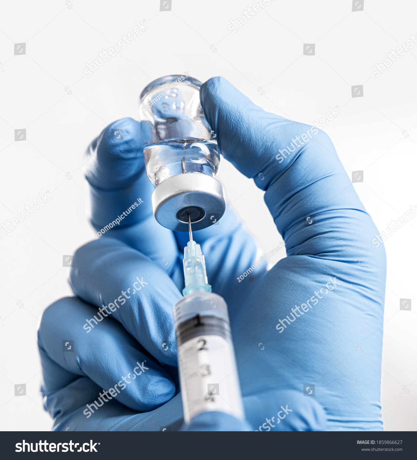 Doctor man holding a syringe with Coronavirus vaccine in his hands. Covid-19 Vaccination #1859866627