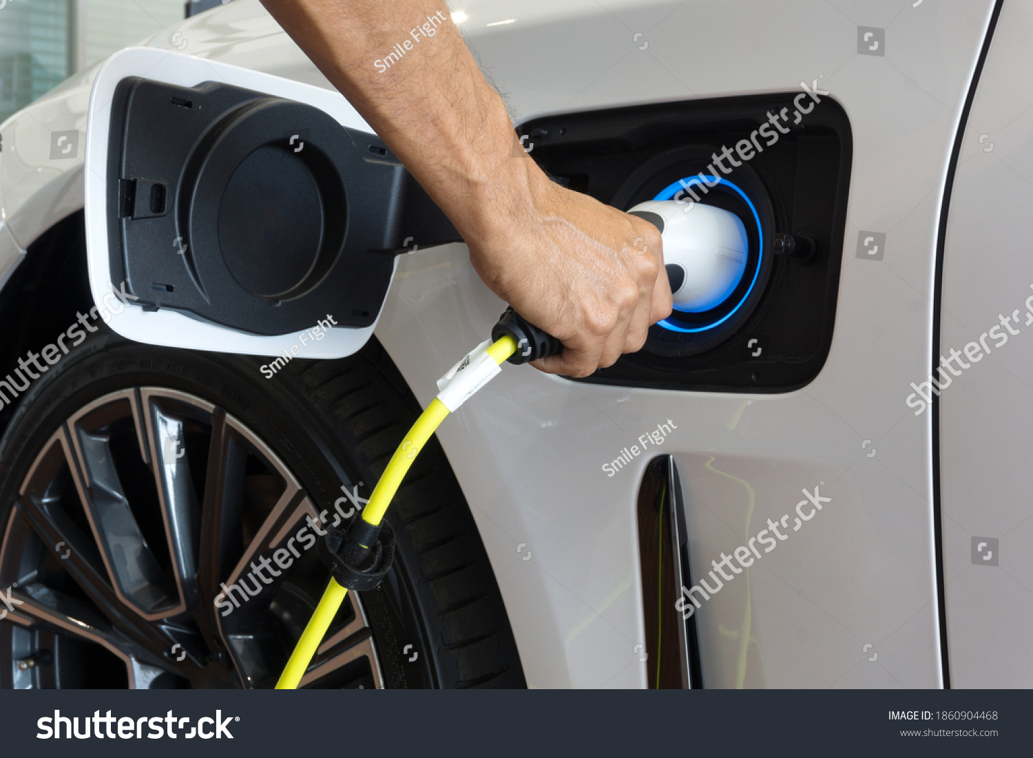 Man hand is holding Electric car charging connect to elecric car on charge station, Electric mobility environment friendly 	 #1860904468
