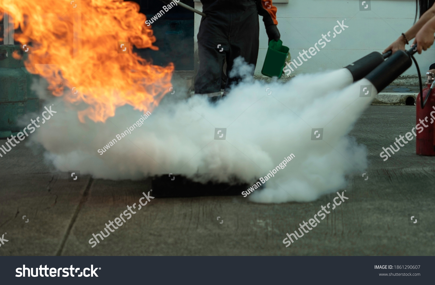 Man teaches or training how to use carbon dioxide (CO2) fire extinguishers to extinguish fires from fuel in house or industry for safety. #1861290607