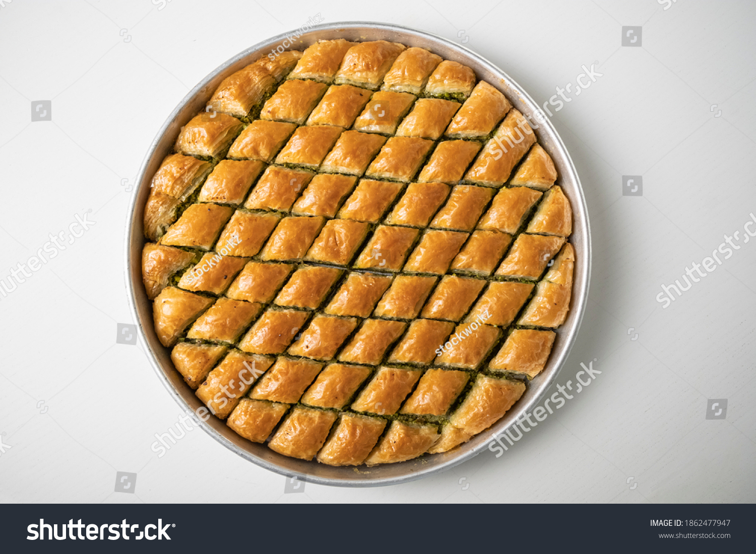 Baklava dessert in a tray sliced in a triangle from traditional Turkish cuisine #1862477947