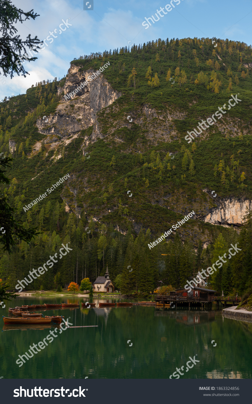 Little chapel and boatshouse at Lake Braies (Pragser Wildsee, Lago di Braies) with boats in foreground. Region of Trentino Alto Adige, Dolomites, Italy #1863324856