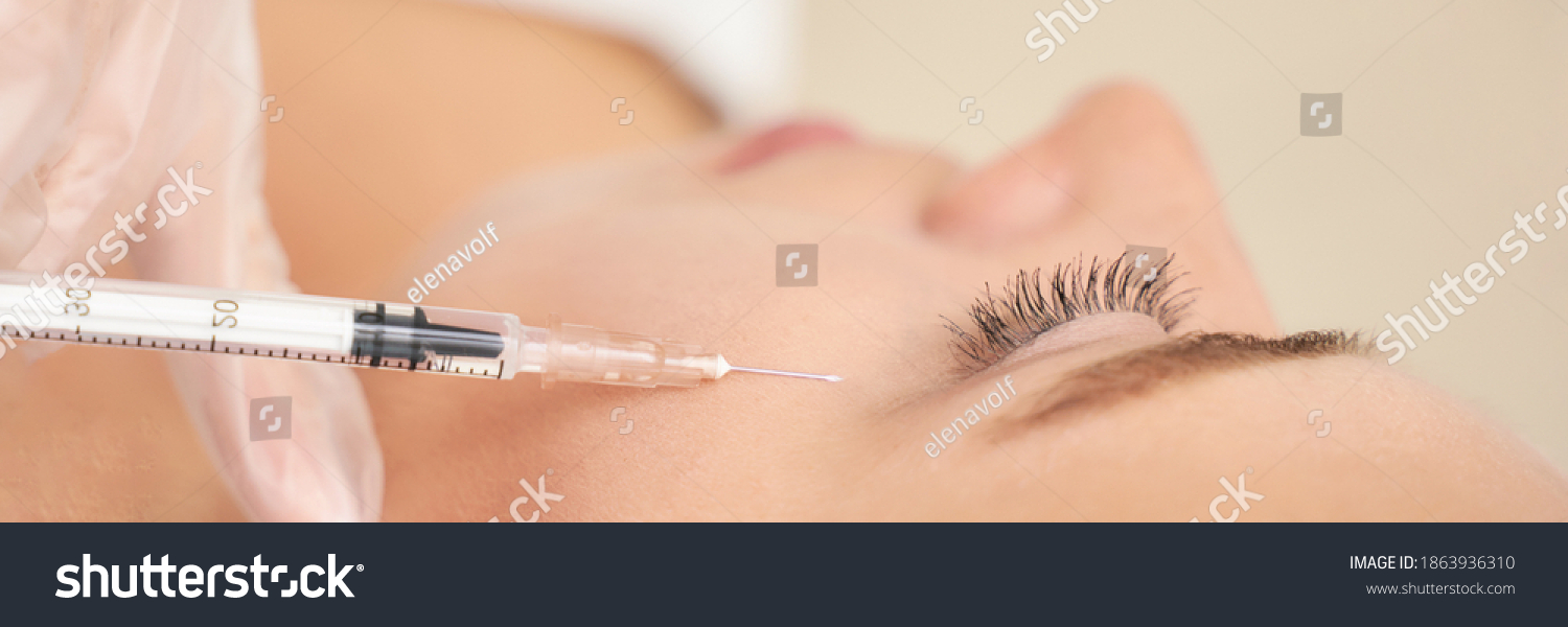 Near eye injection at spa salon. Doctor hands. Closeup. High quality. Pretty female patient. Beauty treatment. Healthy skin procedure. Young woman face. Crows feet wrinkle. Plasmolifting rejuvenation #1863936310