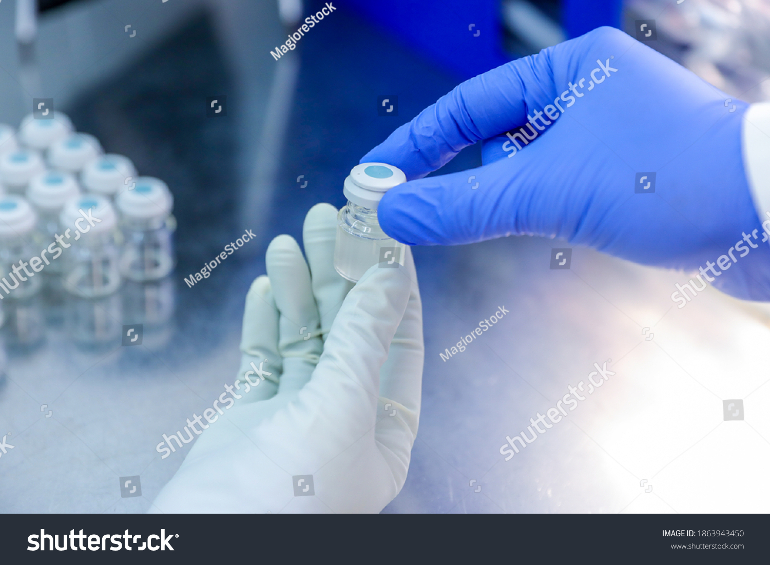 Hand with medical glove holding a bottle vaccine from ice storage. Medication treatment at nitrogen freeze. #1863943450