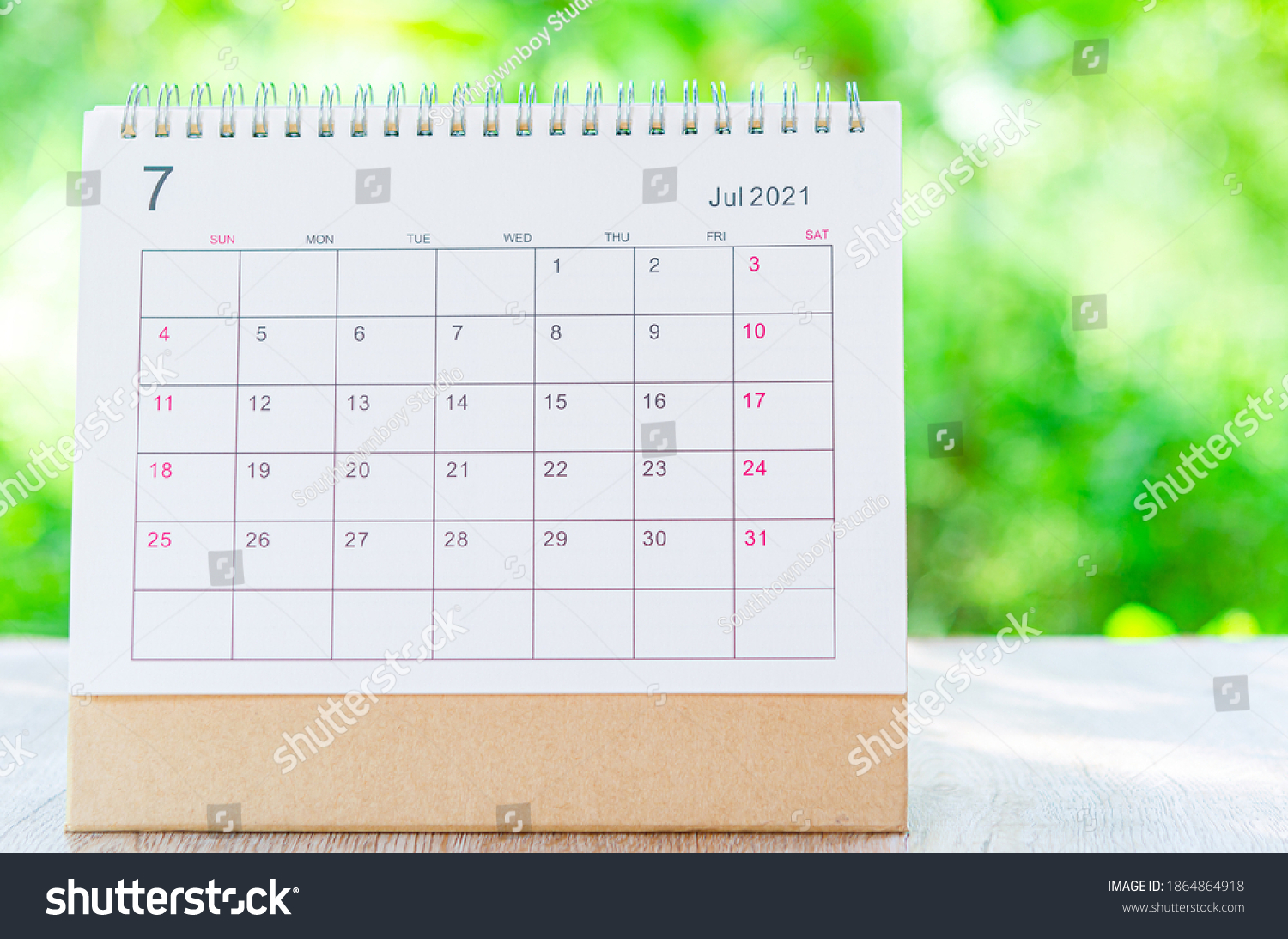 Calendar desk 2021 July month for organizer to plan and reminder on wooden table on nature background. #1864864918