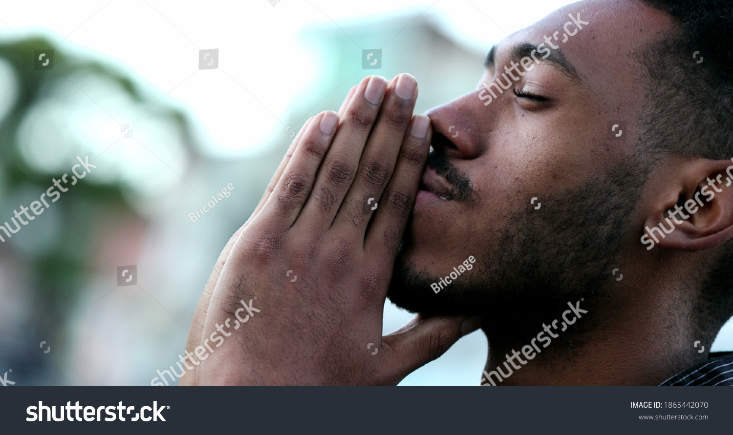 Spiritual young black African man praying to GOD. Person looking to sky with HOPE and FAITH #1865442070
