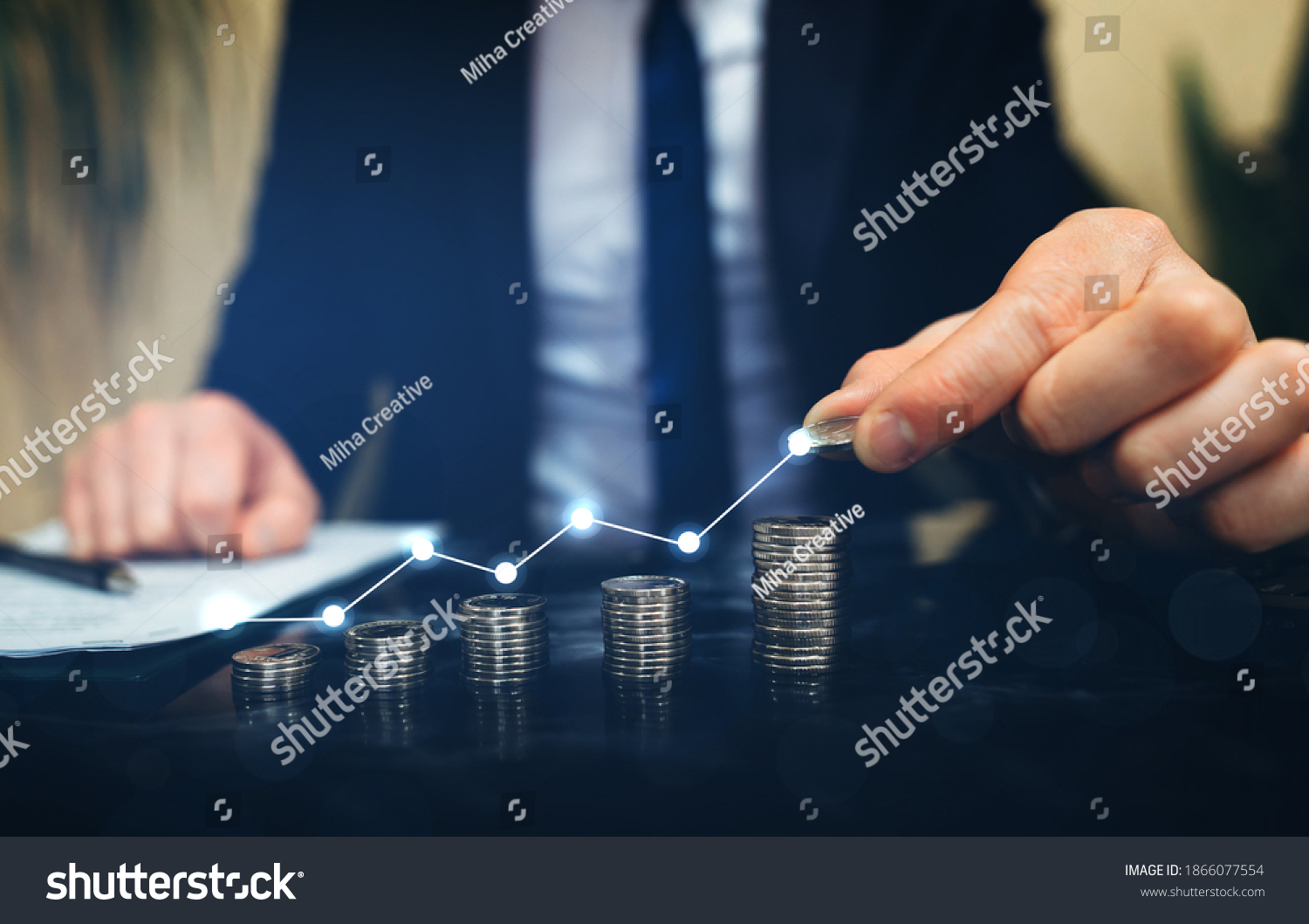Businessman stacking coins with a graph of profit. Business successful  growth #1866077554