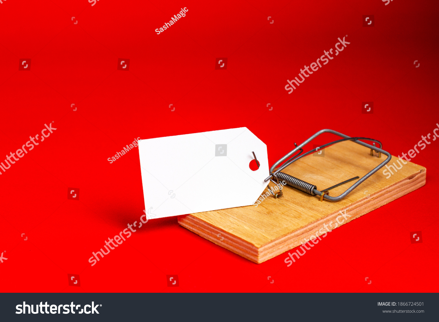 Place for your text, marketing. White paper tag in a wooden mousetrap on a red background. #1866724501