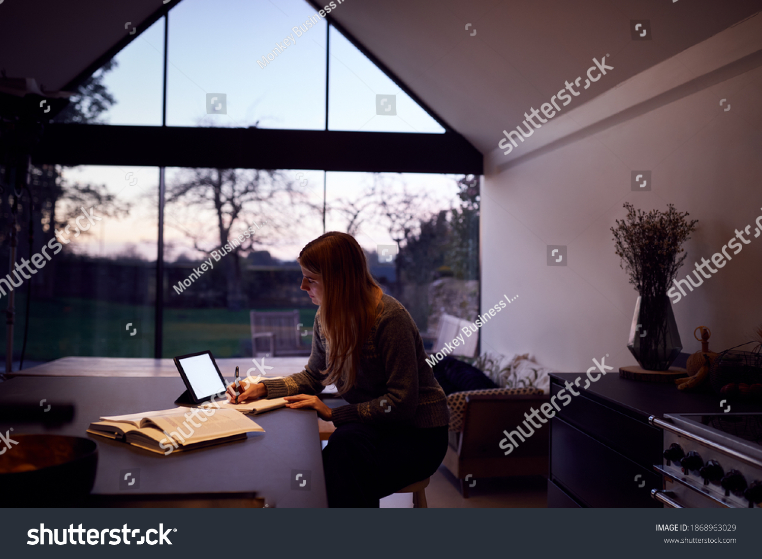 Evening Shot Of Woman In Kitchen Working Or Studying From Home Using Digital Tablet #1868963029