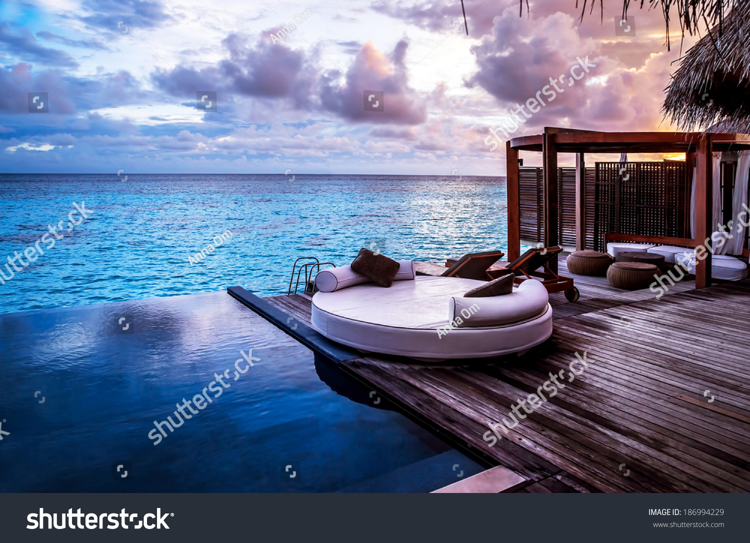 Luxury beach resort, bungalow near endless pool over sea sunset, evening on tropical island, summer vacation concept #186994229