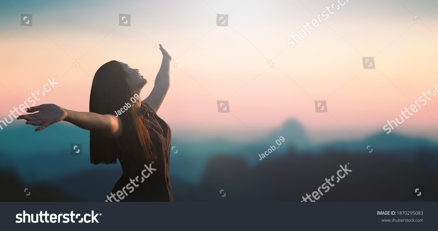 Mental Health concept: Happy girl raised hand on blurred mountain sunrise background. Phang-nga, Thailand, Asia #1870295083