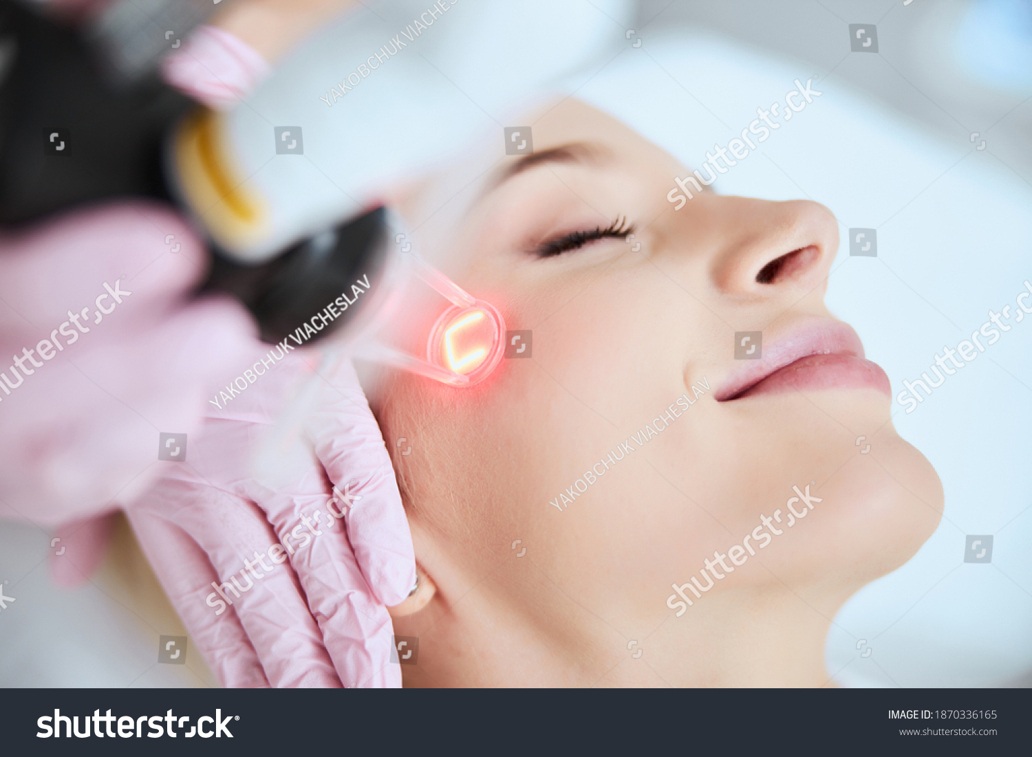 Close up portrait of a young woman patient receiving a laser treatment in a spa salon #1870336165