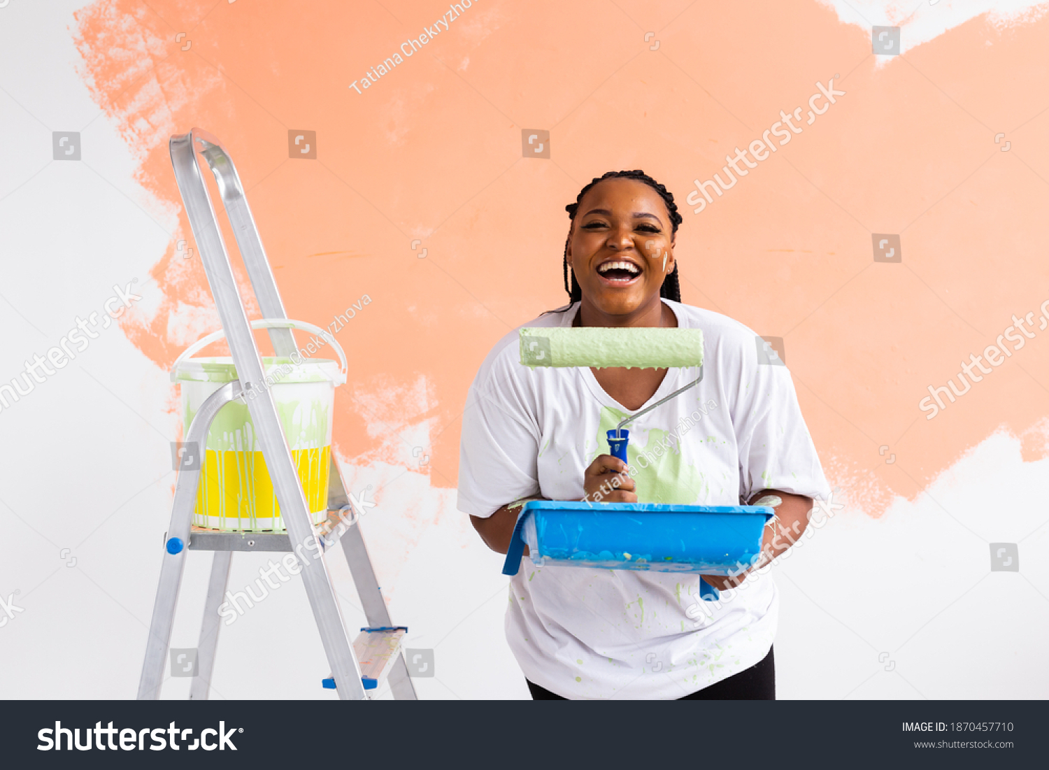Smiling african american woman painting interior wall of home. Renovation, repair and redecoration concept. #1870457710