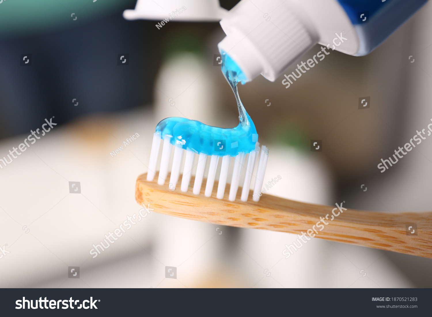 Applying toothpaste on brush against blurred background, closeup #1870521283