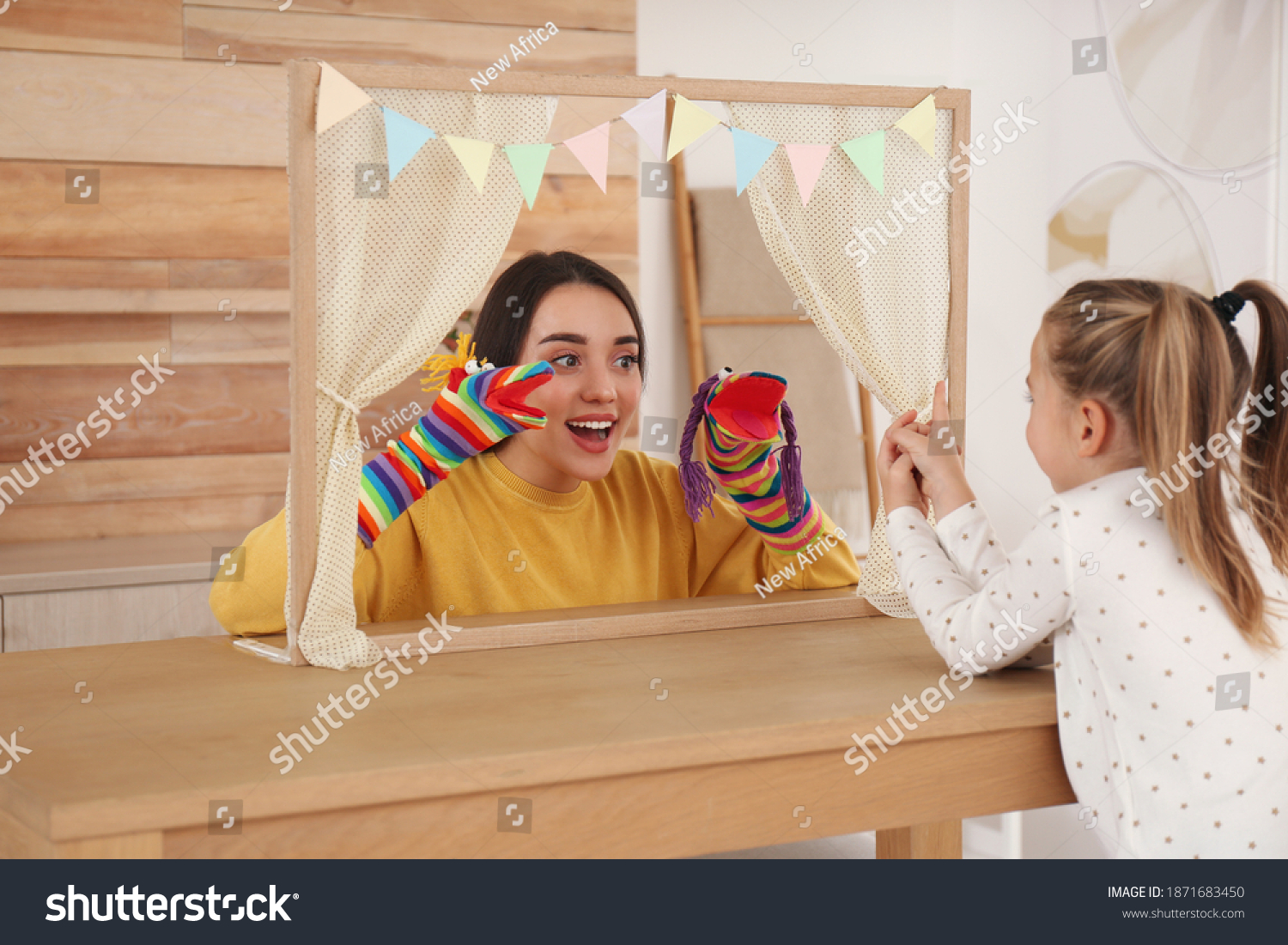 Mother performing puppet show for her daughter at home #1871683450