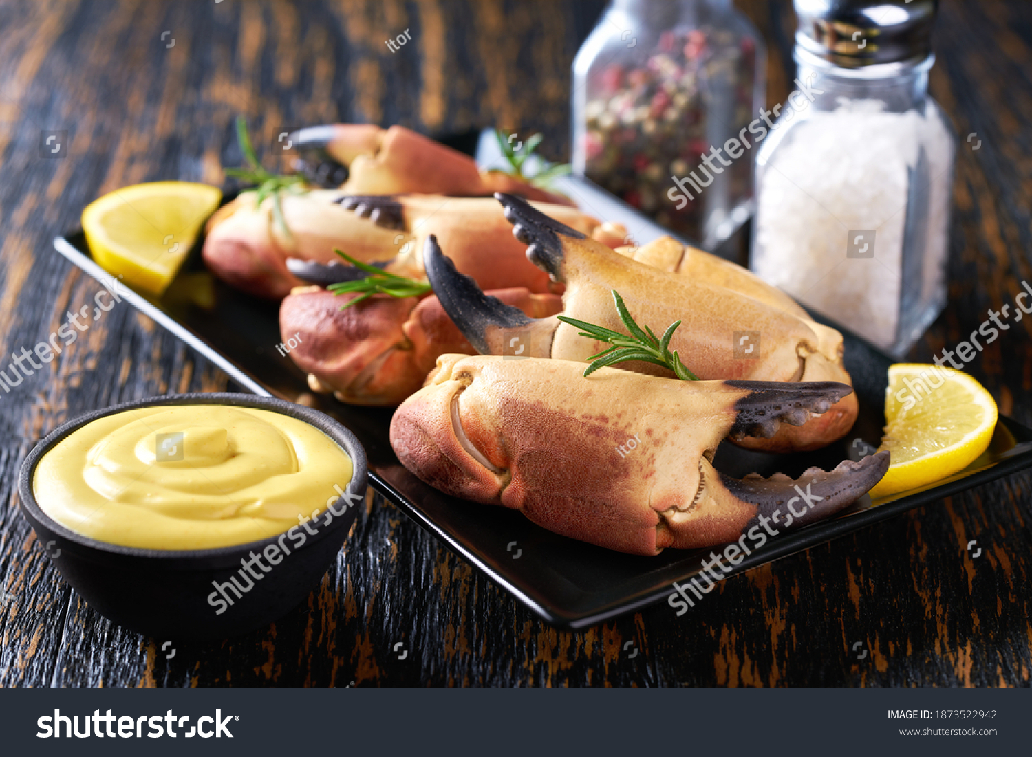 crab claws with  mustard sauce , lemon and rosemary  in a restaurant, close-up. #1873522942