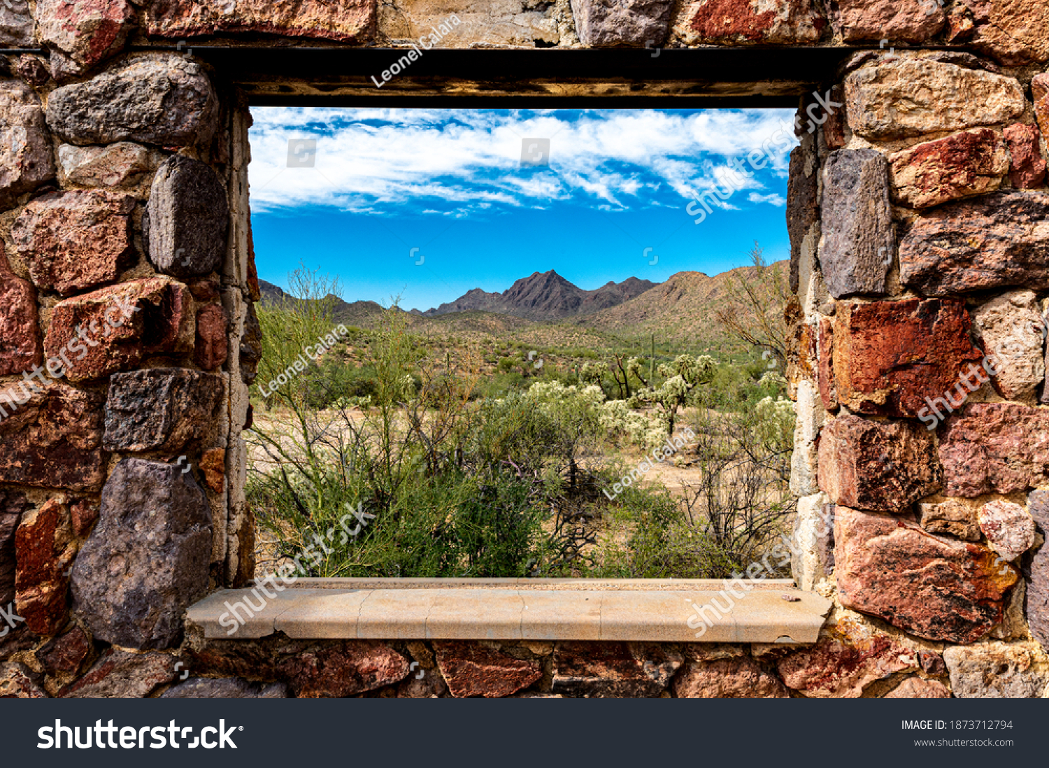 Looking through the window at the picturesque desert landscape from the ruins of a stone house on the Bowen Trail in Tucson Arizona. #1873712794