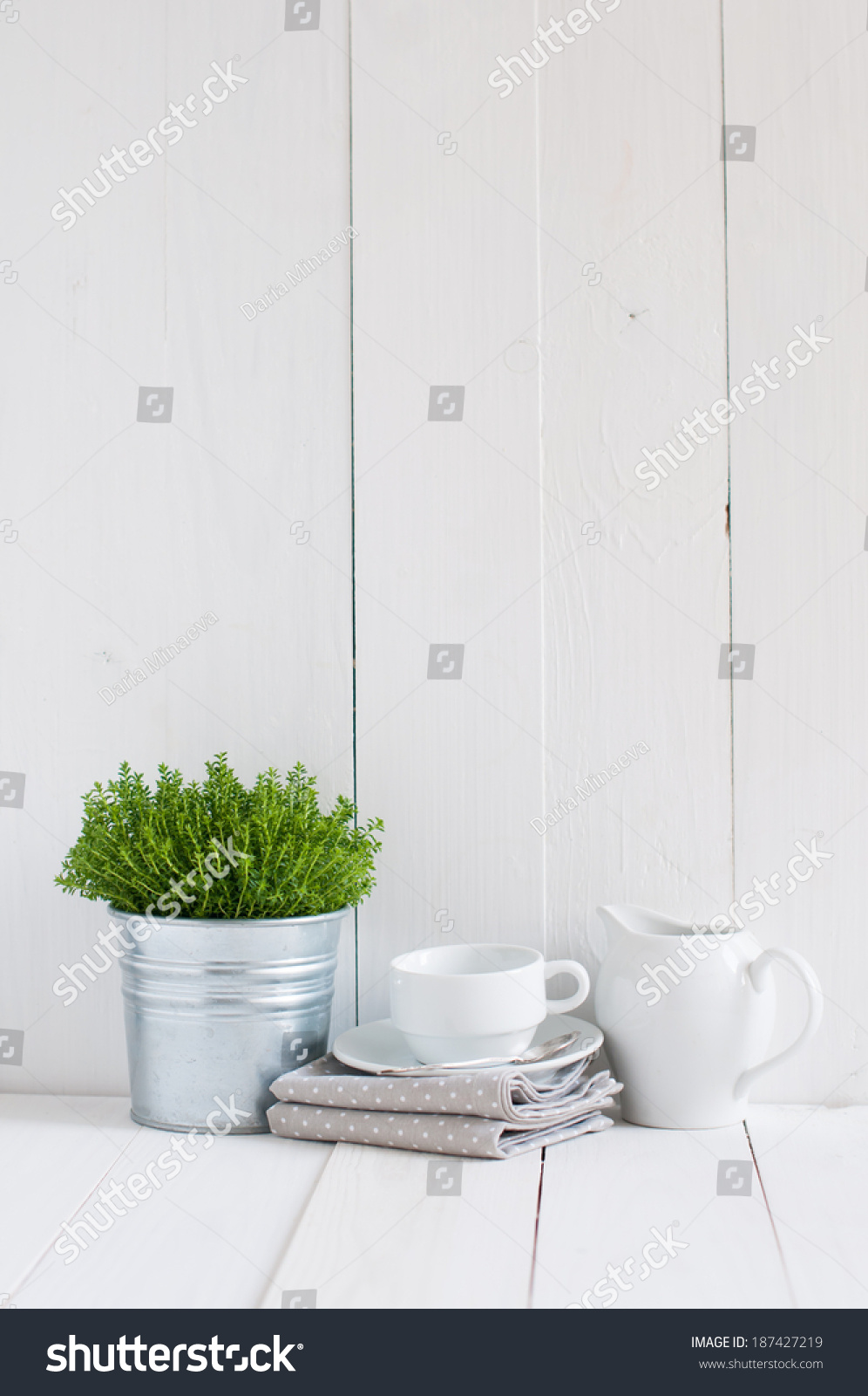 Cottage life, country kitchen decoration: a house plant in a metal pot, kitchen pottery, utensils and napkins on white painted board. Cozy home country life background is. #187427219