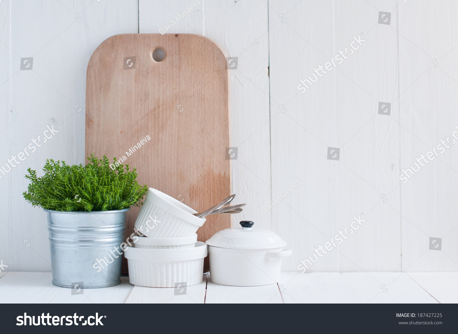 Cottage life, country kitchen decoration: a house plant in a metal pot, kitchen pottery, utensils and napkins on white painted board. Cozy home country life background is. #187427225