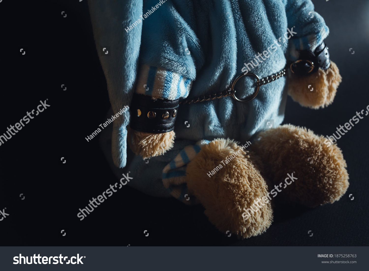 Toy bear is kneeling, facing the wall, hands behind his back in handcuffs. Child abuse. Abduction of children. Slavery and the sale of people. Psychological violence in the family, society and school. #1875258763