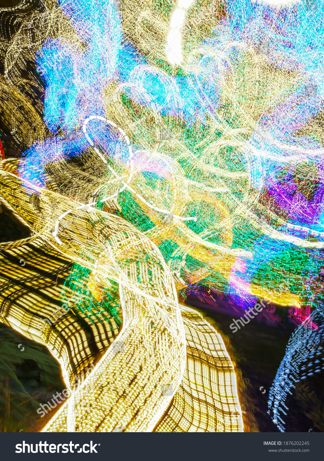 Otherworldly light trails of light-emitting diodes (LEDs) that provide holiday illumination in a festive garden at night. Long exposure with motion blur. Painting with light. #1876202245