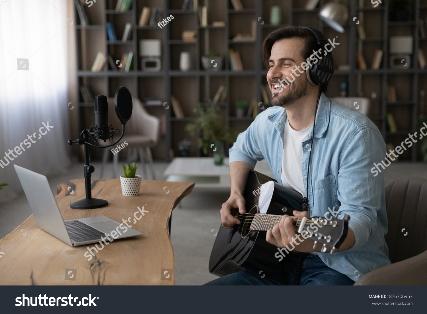 Wide banner view of happy millennial male artist hold guitar take online video webcam lesson on computer. Smiling young man singer or composer use instrument watch music tutorial on laptop at home. #1876706953