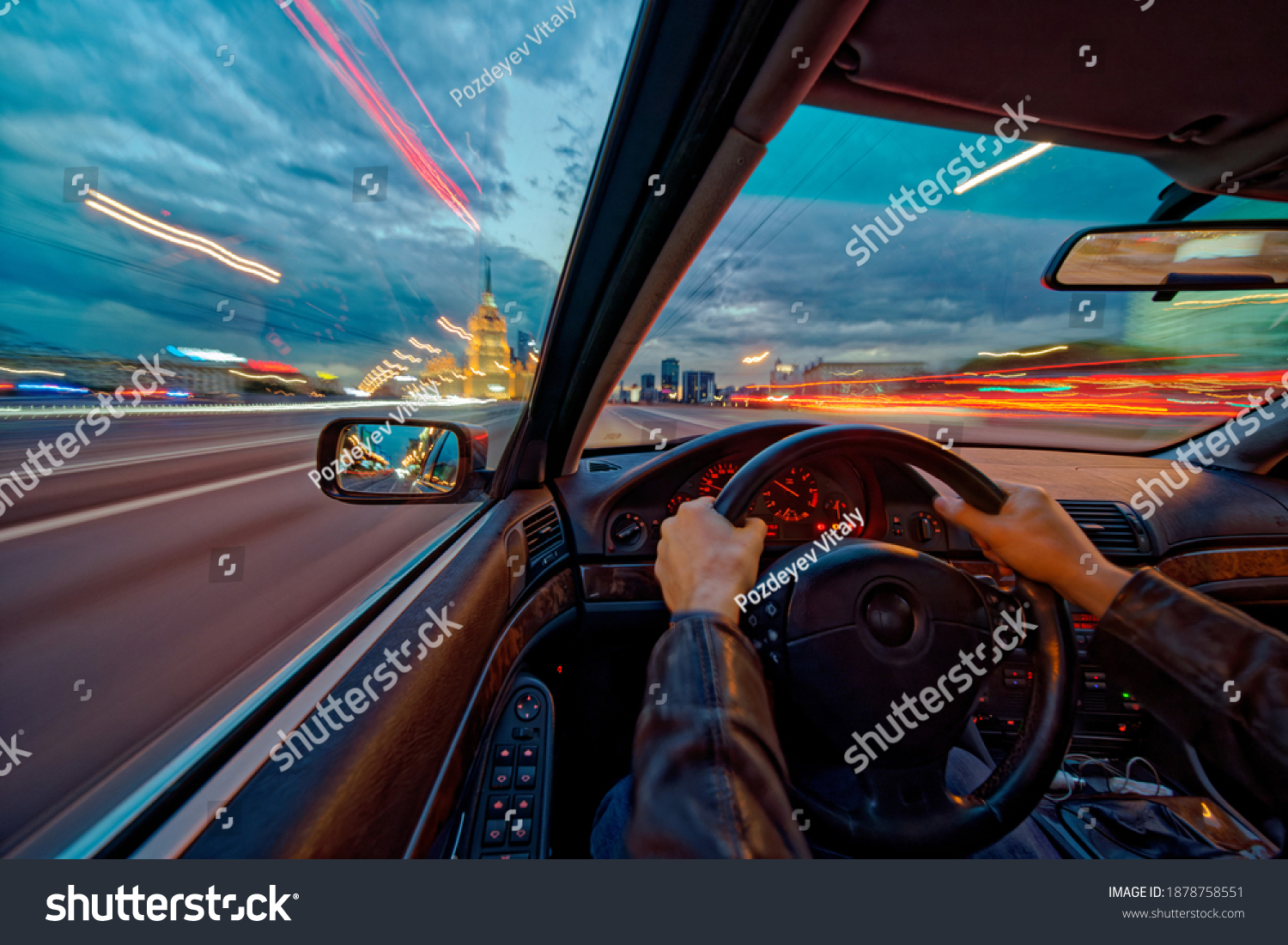 Movement of the car at night at high speed view from the interior with driver hands on wheel. Concept spped of life. Long exposure photo. #1878758551