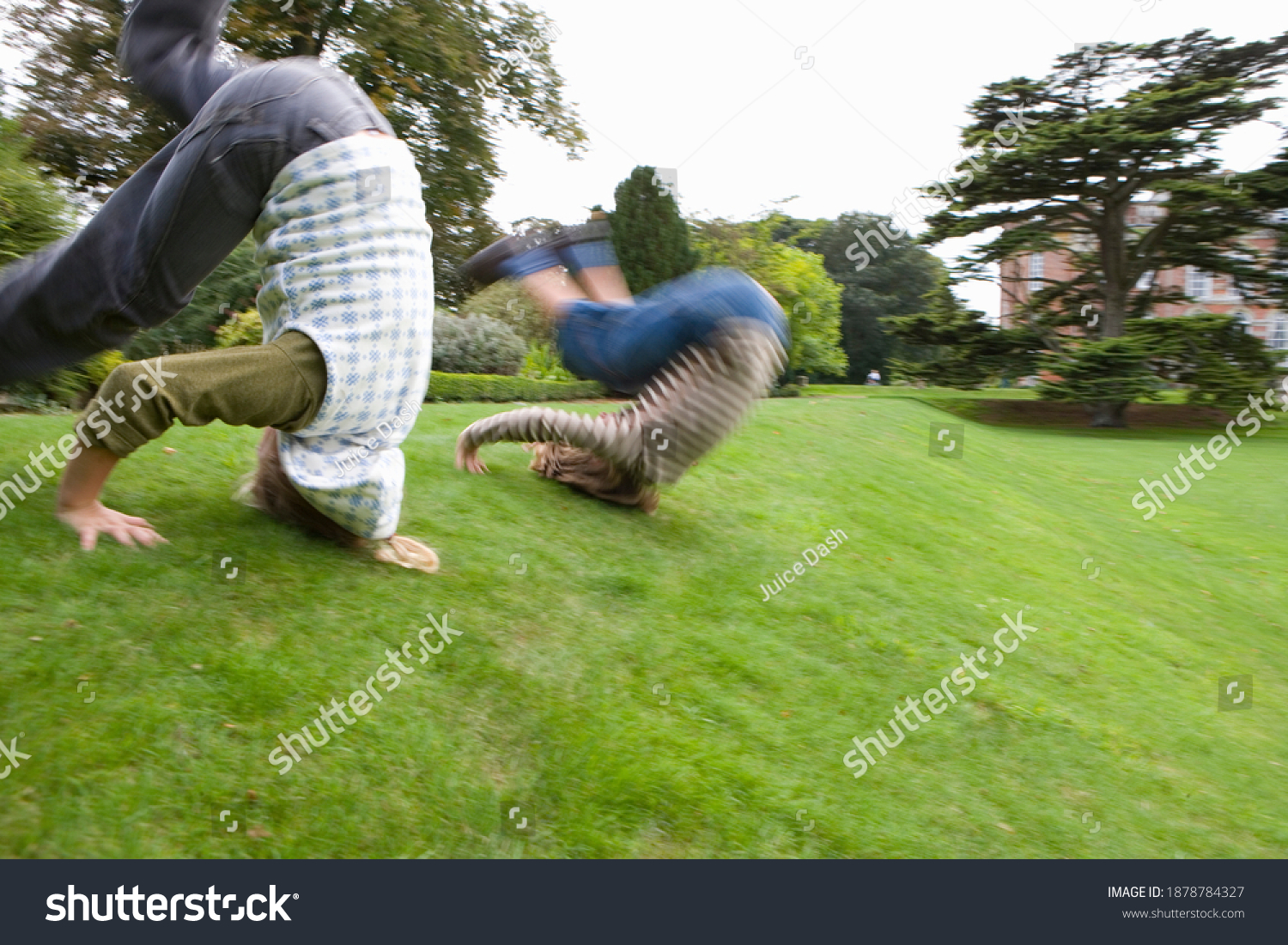 Motion blur of a young boy and a girl rolling down a hill slope. #1878784327