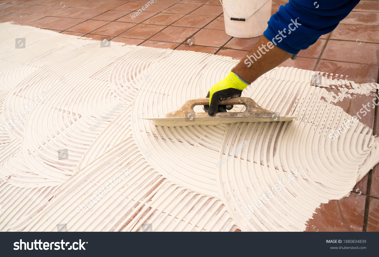 worker applying tile adhesive glue on the floor	 #1880834839