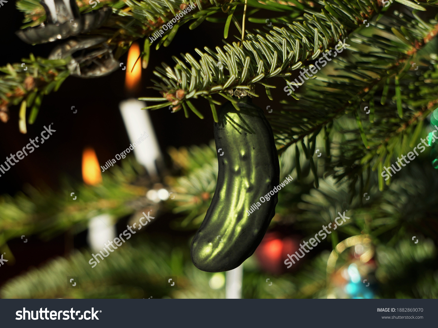 Decorated Christmas Tree With Hidden Glass Cucumber Decoration As Lucky Symbol And White Wax Candles. Festive Green Background. #1882869070