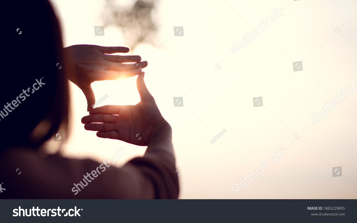 New year planning and vision concept, Close up of woman hands making frame gesture with sunset, Female capturing the sunrise. copy space. #1883229895
