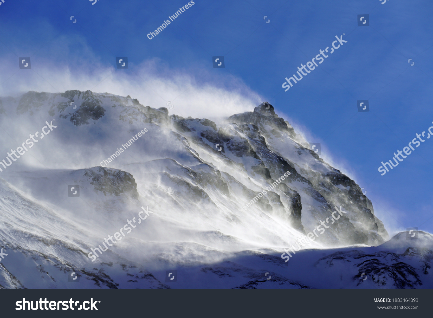 strong south wind in the alps in winter on a sunny day in the national park hohe tauern in austria #1883464093