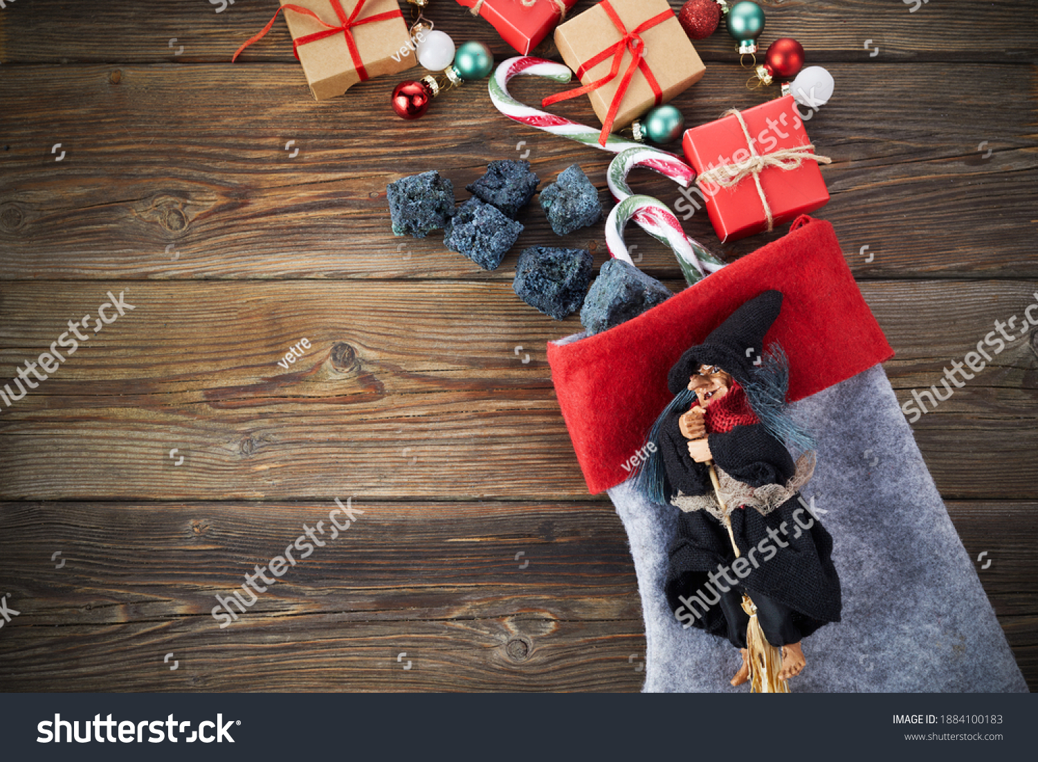 The Befana with sweet coal and candy on wooden background. Italian Epiphany day tradition. #1884100183