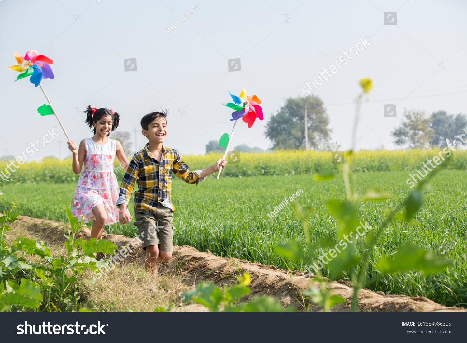 Rural kids playing in  agricultural field with windmill #1884986305