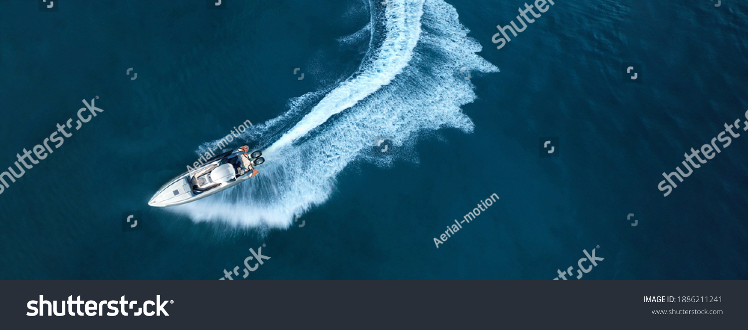 Aerial drone top down ultra wide photo of inflatable power rib boat making extreme manoeuvres in Mediterranean bay with deep blue sea at dusk #1886211241