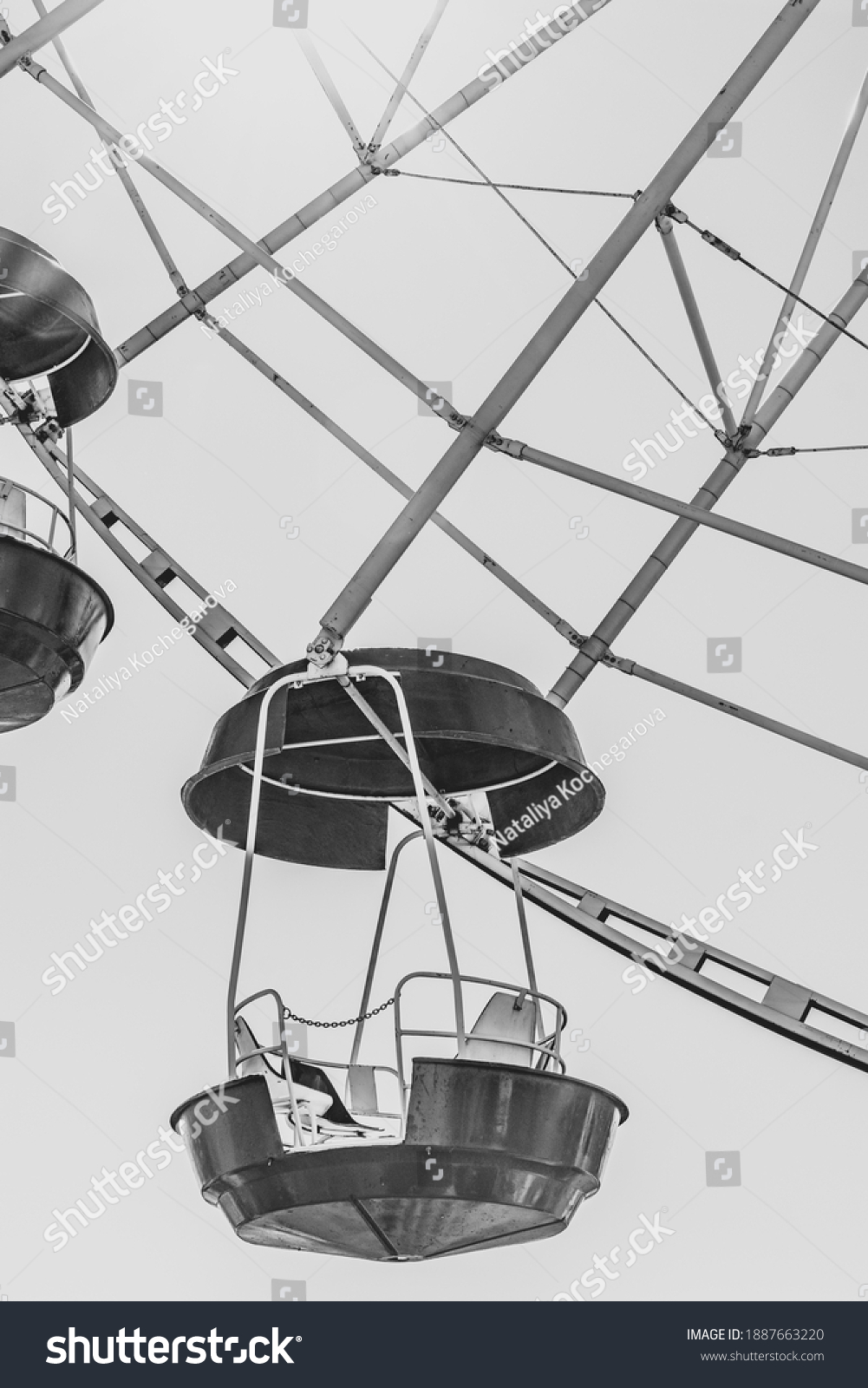 Ferris wheel booths in black and white image. The cabin of the Ferris wheel against the sky on top.Background image of the Ferris wheel. vertical image #1887663220
