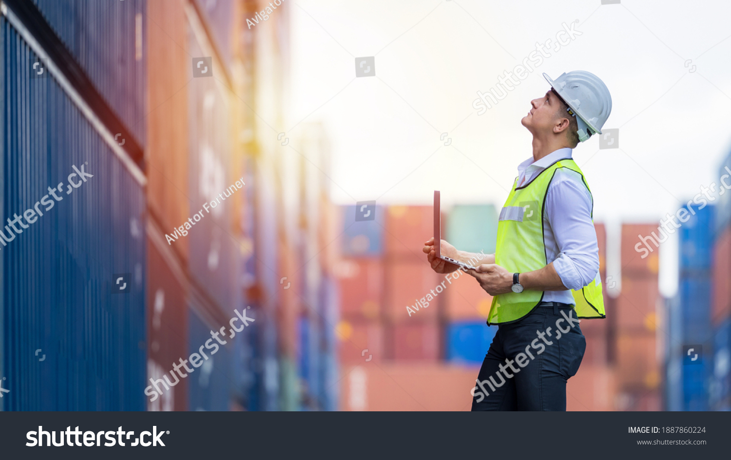Engineer dock worker wear safety uniform check control loading freight cargo container use computer laptop at commercial dock warehouse, Global business logistic transportation cargo freight shipping. #1887860224