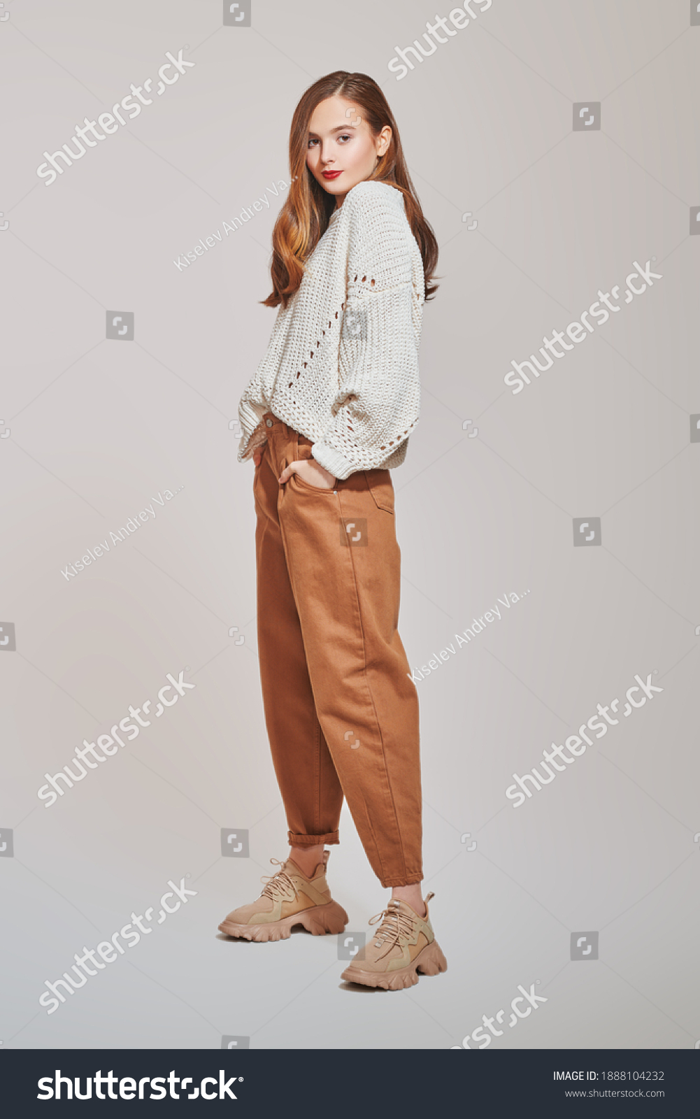 Fashion shot. Beautiful young girl in modern casual clothes posing at studio. Full length portrait.   #1888104232