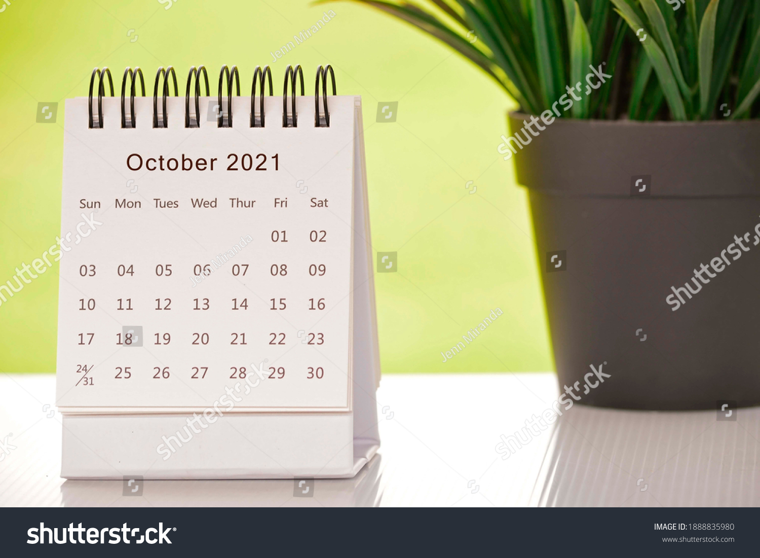 White October 2021 calendar with green backgrounds and potted plant. 2021 New Year Concept #1888835980