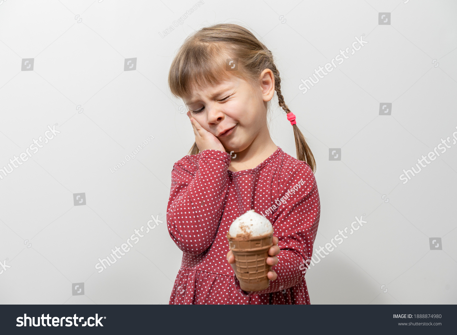 child has a toothache while eating ice cream. sensitivity of teeth to cold #1888874980