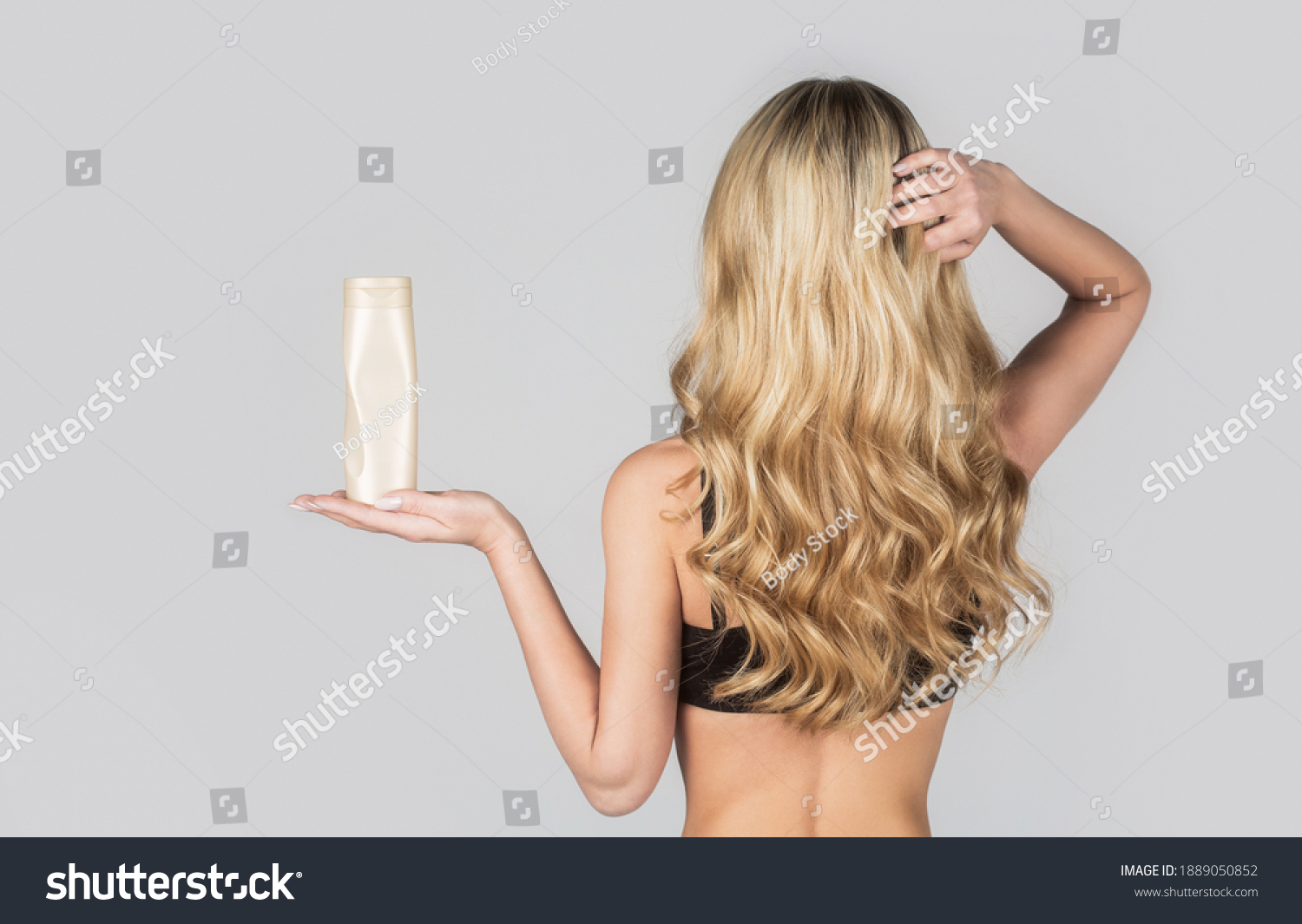 Beautiful blonde girl with a bottle of shampoos in hands. Girl with shiny and long hair. Woman long hair. Woman hold bottle shampoo and conditioner. Woman holding shampoo bottle. #1889050852