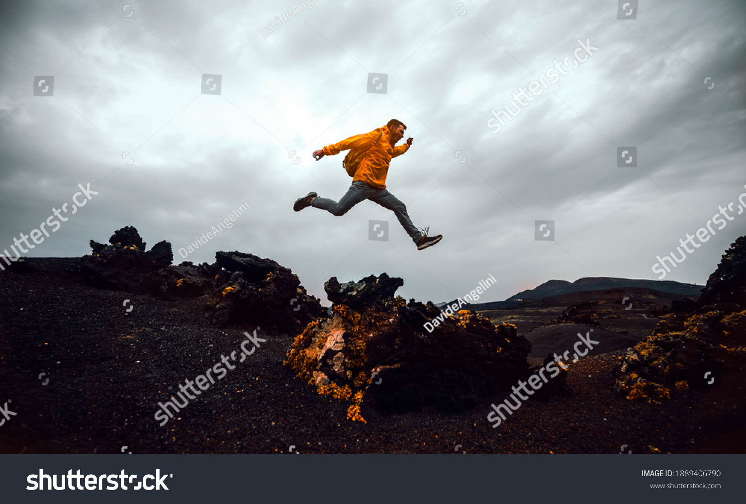 Hiker man jumping over the mountain. Freedom, risk, success and  #1889406790