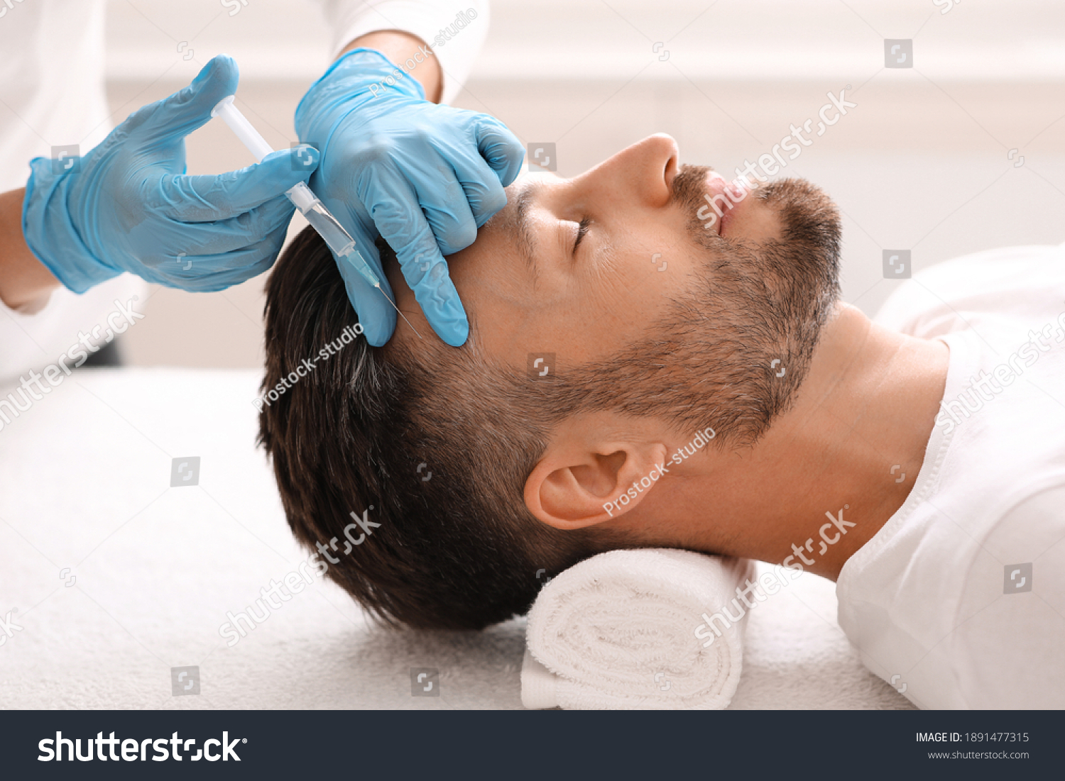 Side view of handsome middle aged man getting hair treatment at beauty salon. Man having mesotherapy session at aesthetic clinic, therapist hands in gloves making injection in scalp, closeup #1891477315