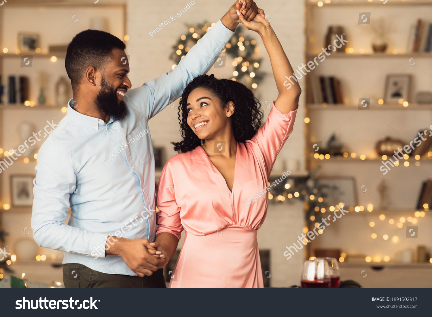 Happy Loving Family. Portrait of beautiful young african american couple in love dancing and looking at each other. Smiling black bearded man having fun with his pretty excited woman #1891502917