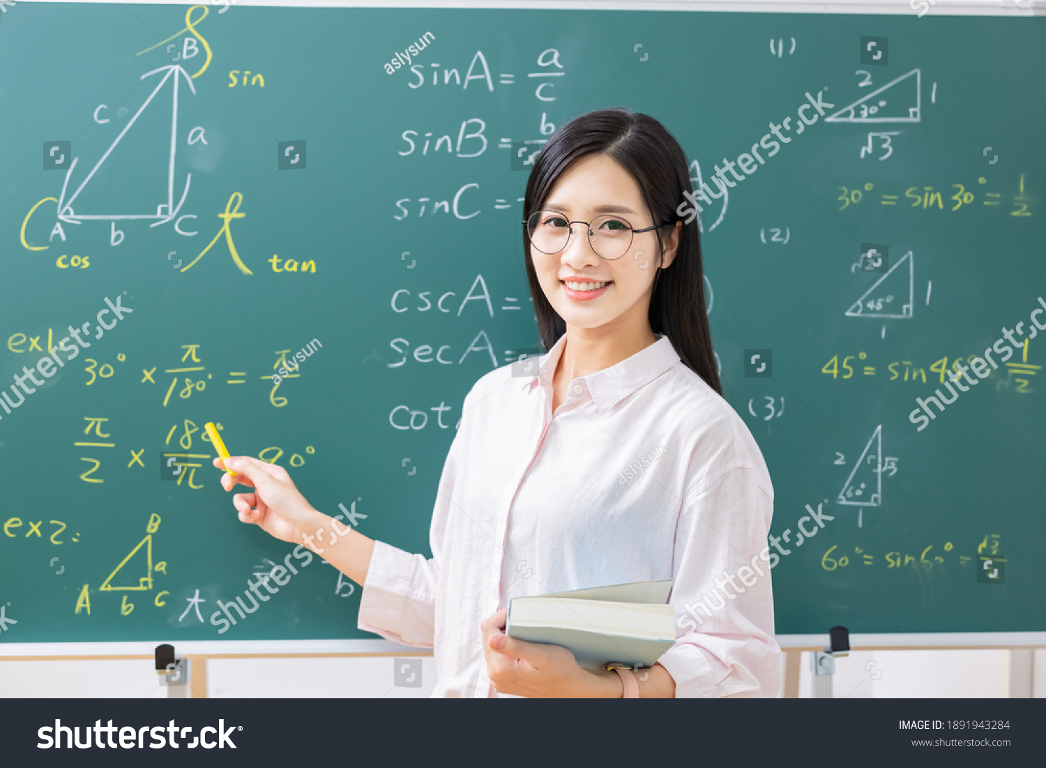 asian senior high school female teacher is teaching online through webcam in classroom #1891943284