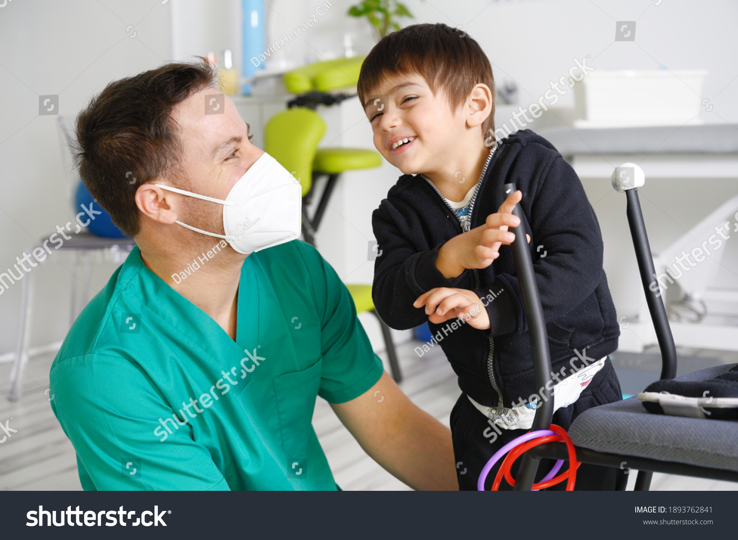 Child with cerebral palsy on physiotherapy in a children therapy center. Boy with disability doing exercises with physiotherapists in rehabitation centre. High quality photo. #1893762841