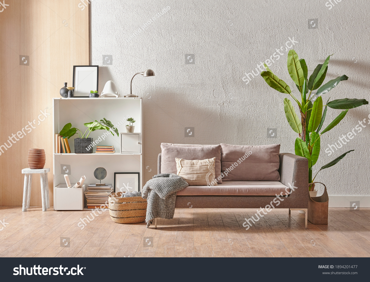 Grey stone wall interior room with wooden decor, bookshelf, sofa and vase of plant, middle table, carpet, home decoration. #1894201477