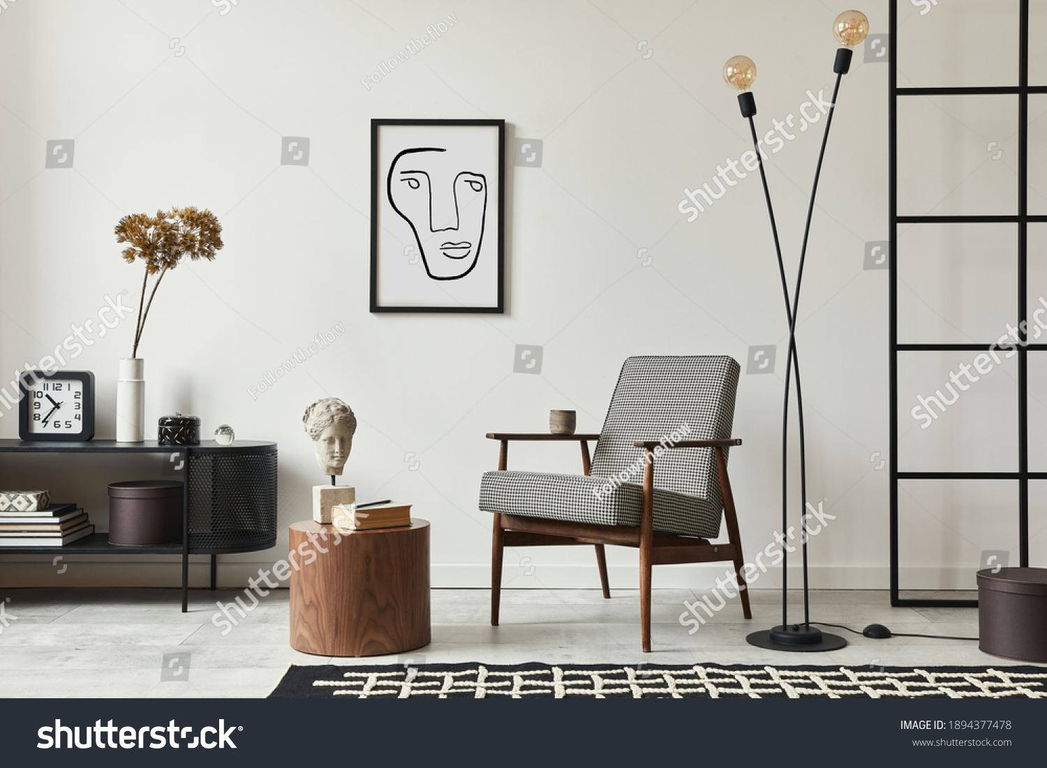 Stylish scandinavian composition of living room with design armchair, black mock up poster frame, commode, wooden stool, book, decoration, loft wall and personal accessories in modern home decor. #1894377478
